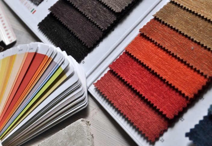 Amostras de tecidos e leque de cores utilizados na seleção e validação de materiais em processos de sourcing têxtil.